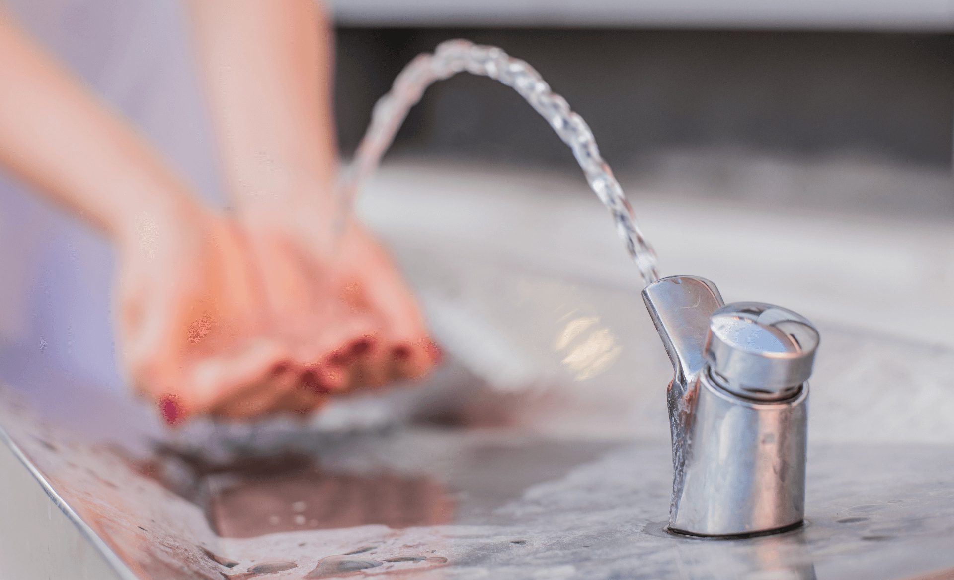 woman fetching drinking water from fountain