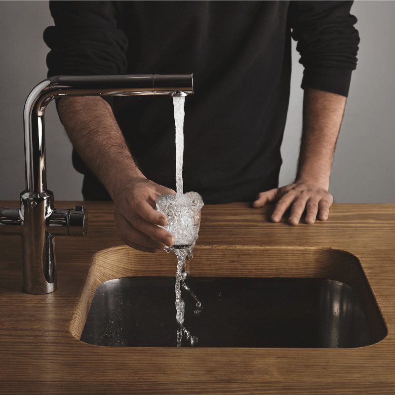 wooden-table-rinses-small-tranparent-glass man wearing black shirt rinsing transparent glass